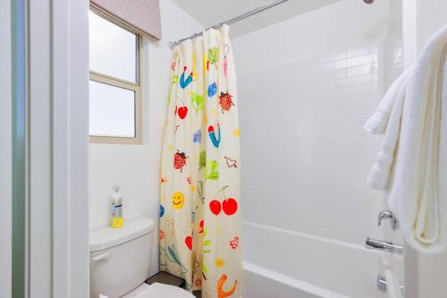 a bathroom with a shower curtain with birds on it at 7BR Pickleball Firepit Outdoor Kitchen Game Room in Coachella