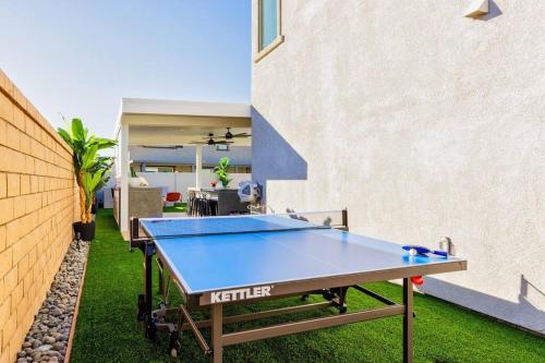 a ping pong table in the backyard of a house at 7BR Pickleball Firepit Outdoor Kitchen Game Room in Coachella