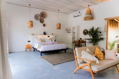 une chambre avec un lit, un canapé et des chaises dans l'établissement ANANA PRIVATE VILLA nusa penida, à Nusa Penida