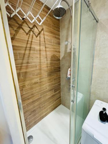 une douche avec une porte vitrée dans une salle de bain dans l'établissement Cosy Appartement Paris proche des Jeux Olympiques, à Pierrefitte-sur-Seine