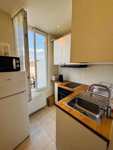 Il comprend une cuisine équipée d'un évier et d'un réfrigérateur. dans l'établissement Cosy Appartement Paris proche des Jeux Olympiques, à Pierrefitte-sur-Seine
