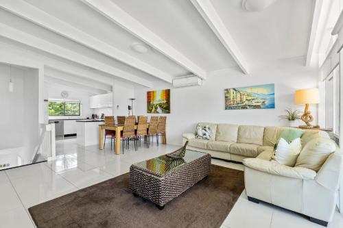 a living room with a couch and a table at Sabia Beach House 2.0 - Beachfront - Sleeps 6 in Vincentia