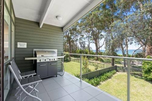 a patio with a stove and a chair on a balcony at Sabia Beach House 2.0 - Beachfront - Sleeps 6 in Vincentia