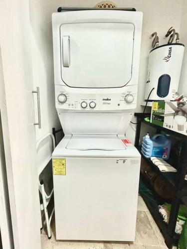 a microwave sitting on top of a small refrigerator at Spacious and comfortable apartment w pool and golf in Tulum