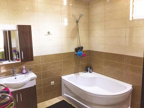 a bathroom with a bath tub and a sink at Villa Aragvi in Mtskheta