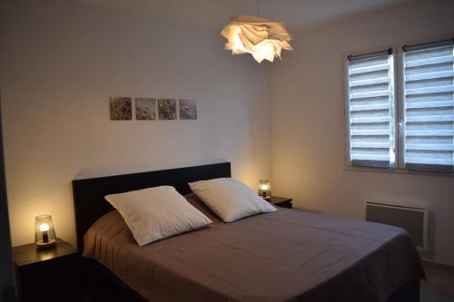 a bedroom with a bed with two pillows and a light at Harmonia sur Moment-Ardeche-com in Rosières