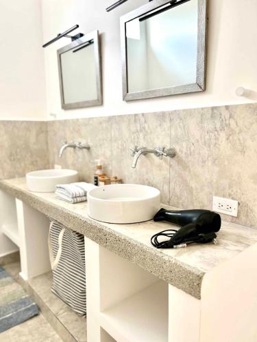 a bathroom counter with two sinks and a mirror at Yellow Heron House in Puerto Villamil