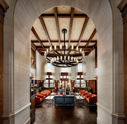 a large lobby with red couches and a large chandelier at Fairmont Hotel Macdonald in Edmonton