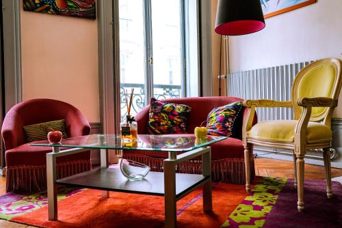 - un salon avec deux chaises et une table en verre dans l'établissement Le St Amour Élégant 2 chambres *Wifi/Super Centre*, à Besançon