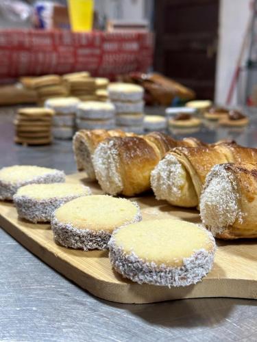 a bunch of pastries sitting on a wooden cutting board at CaminAndes Hostal in San Pedro de Atacama