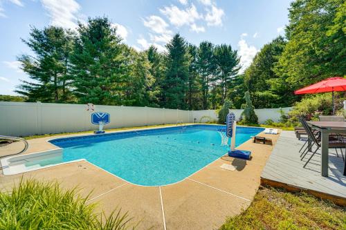 a swimming pool in a backyard with a table and umbrella at Pool, Yard and Game Room Family Home in Kunkletown in Effort