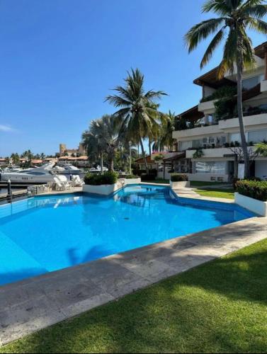 a large blue swimming pool next to a building at Marina-Access Apartment in peaceful Ixtapa in Ixtapa