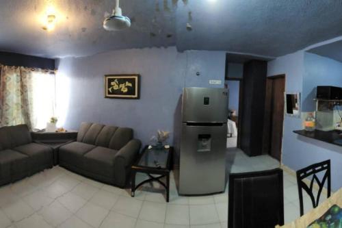ein Wohnzimmer mit Couch und Kühlschrank in der Unterkunft Departamento en el corazón de cozumel in Cozumel