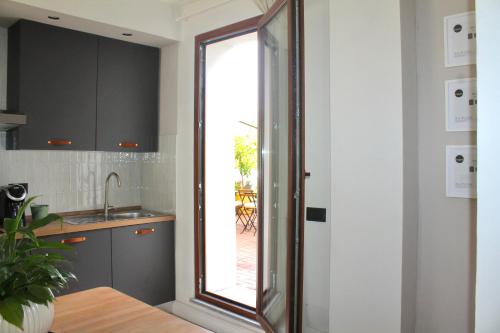 a kitchen with a large glass window and a table at Il Cortile del Borgo in Borgo Ticino