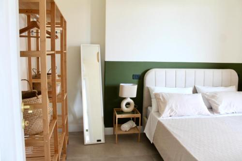 - une chambre dotée d'un lit avec un mur vert dans l'établissement Il Cortile del Borgo, à Borgo Ticino