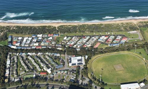 an aerial view of a large group of houses next to the ocean at Wollongong Surf Leisure Resort in Wollongong