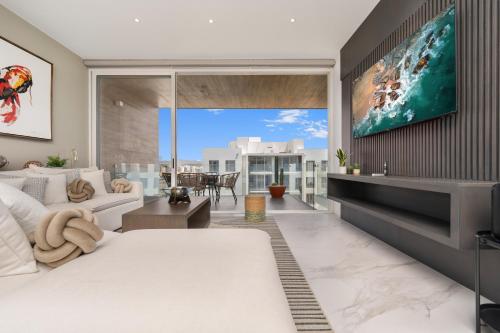 a living room with a tv on a wall at New Penthouse in Medano with Jacuzzi and Terrace in Cabo San Lucas