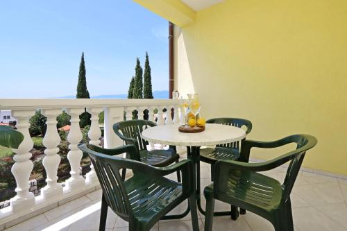 a table and chairs on a balcony with a view at Apartments with parking space Kostrena, Rijeka - 23422 in Kostrena