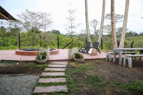 a patio with two chairs and a bench and a table at Casa Piamonte Quindío in Circasia