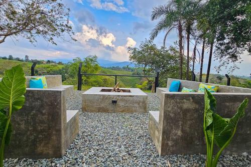 a patio with two benches and a fire pit at Casa Piamonte Quindío in Circasia