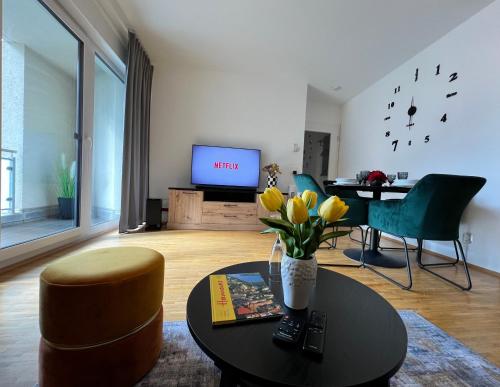 ein Wohnzimmer mit Tisch und Fernseher in der Unterkunft Modernes Apartment mit Balkon und Parkplatz Zentrum in Hannover