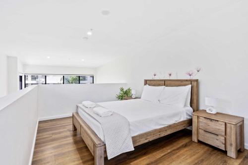 Un dormitorio blanco con una cama y una mesa. en The Aubrey Boutique Apartments - Hosted by Coastal Letting Co., en Gold Coast