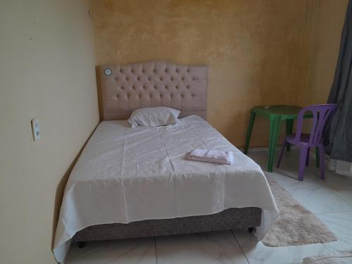 a bedroom with a bed with a white comforter at Hotel Ramos in Barreirinhas