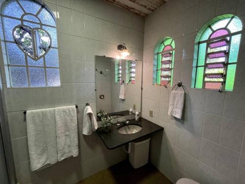 a bathroom with a sink and stained glass windows at Recanto do Coração in Itaúna