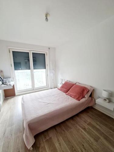 une chambre blanche avec un lit et deux fenêtres dans l'établissement Superbe appartement au pied du RER A et l'Arena, à Nanterre
