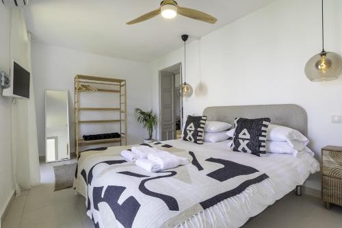 a bedroom with a bed with black and white pillows at Casa Jardin Competa in Cómpeta