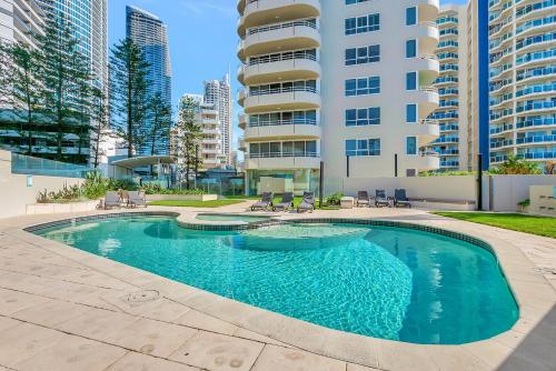 a swimming pool in front of a apartment building at Zenith Apartments - Q Stay in Gold Coast