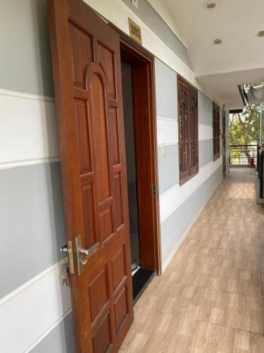 an empty corridor with a wooden door and a hallway at HOTEL AN HOÀ II in Ba Ria