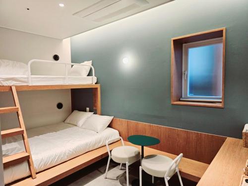 a small room with a bunk bed and a table at Huga Inn in Seoul