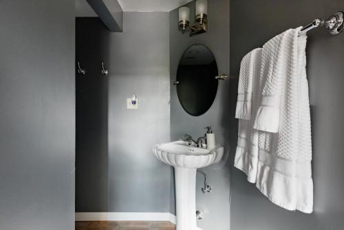 a white bathroom with a sink and a mirror at Chic Spot near the Lower French Quarter in New Orleans