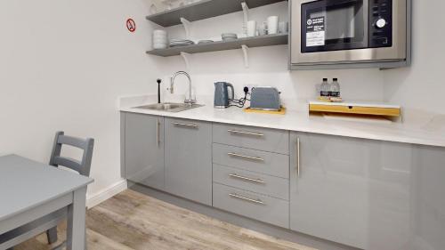a kitchen with a sink and a microwave at Bicester Court in Bicester