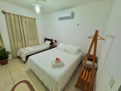 a bedroom with two beds and a chair in it at Casa Praia Beira Mar "TÉRREO" Guriú,Ce in Guriú