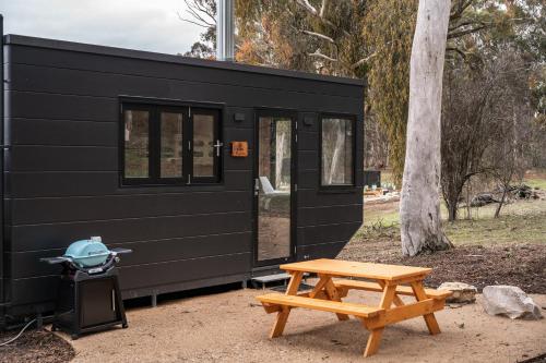 a black tiny house with a picnic table next to it at CABN Hahndorf in Hahndorf