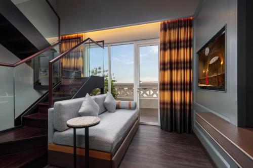 a living room with a couch and a large window at The George Penang by The Crest Collection in George Town