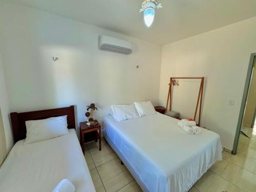 a bedroom with two beds and a nightstand and sidx sidx sidx sidx at Casa Praia Beira Mar "TÉRREO" Guriú,Ce in Guriú