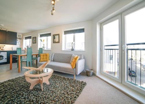 a living room with a couch and a table at 2 Bed Charming Corner Position Apartment in Kidlington