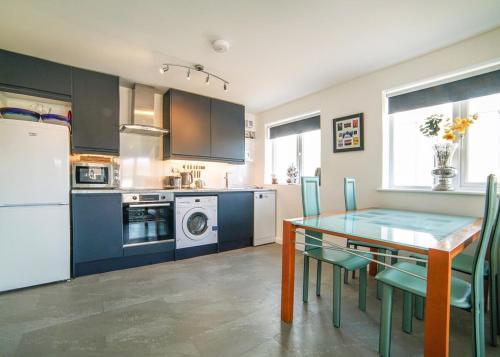 a kitchen and dining room with a table and chairs at 2 Bed Charming Corner Position Apartment in Kidlington