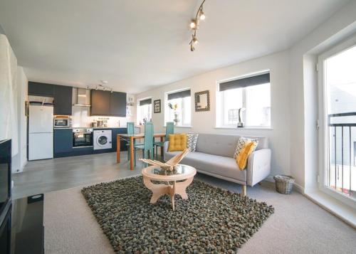a living room with a couch and a table at 2 Bed Charming Corner Position Apartment in Kidlington