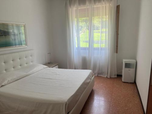 a bedroom with a white bed and a window at Ranco Villa Lina in Ranco