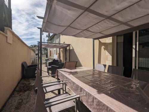 a patio with a table and chairs and an umbrella at Chambre "Étoile Brune" avec Salle d'eau Privative et Petit-Déjeuner Inclus, Neuvy-Saint-Sépulchre - FR-1-591-607 in Neuvy-Saint-Sépulchre