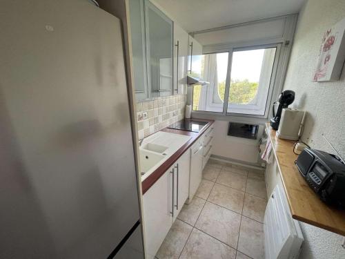 une petite cuisine avec un évier et une fenêtre dans l'établissement Appartement 3 Pièces, Piscine, Proche Plage, Wi-Fi, Garage - FR-1-328-269, à La Grande Motte