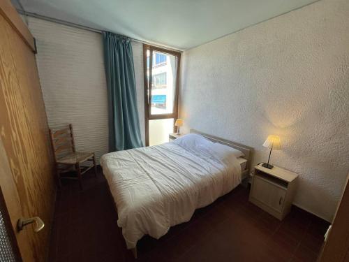 une petite chambre avec un lit et une fenêtre dans l'établissement Saint-Cyprien : T2 confortable en bord de mer avec parking et animaux admis - FR-1-106-106, à Saint-Cyprien