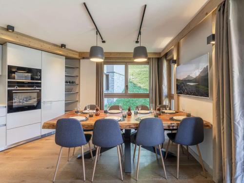 une salle à manger avec une grande table en bois et des chaises bleues dans l'établissement Appartement 8 pers, centre Courchevel, accès pistes, SPA, idéal familles - FR-1-631-203, à Courchevel