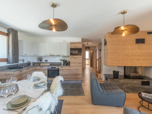 une cuisine et un salon avec une table et des chaises dans l'établissement Duplex neuf avec balcon, cheminée, proche des pistes à l'Alpe d'Huez - FR-1-645-73, à Huez