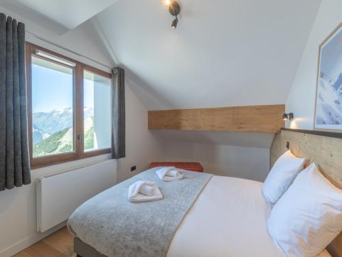 une chambre avec un lit avec deux serviettes dessus dans l'établissement Duplex neuf avec balcon, cheminée, proche des pistes à l'Alpe d'Huez - FR-1-645-73, à Huez