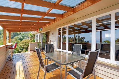 a patio with a table and chairs on a deck at Tahuna Views - Spa Pool, Sea Views, Great for Kids in Nelson
